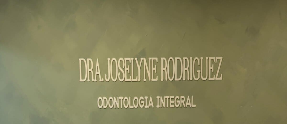 El muro verde salvia de la recepción con el letrero Dra. Joselyne Rodriguez, Odontología Integral