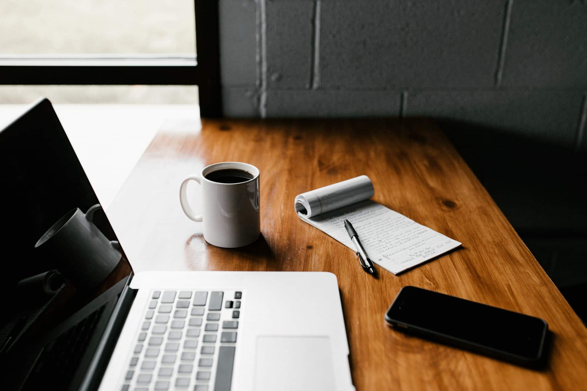 Laptop y taza de café sobre un escritorio de madera
