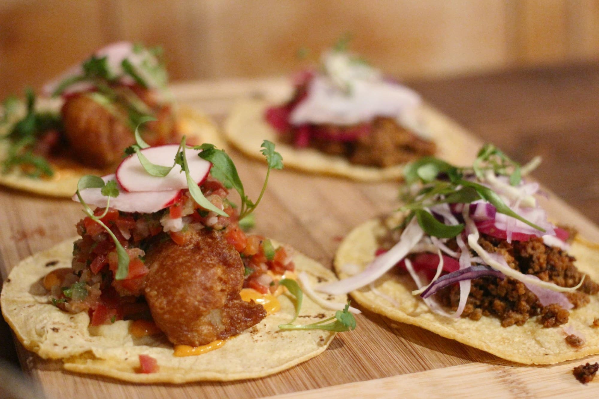 Tacos servidos sobre una tabla de madera