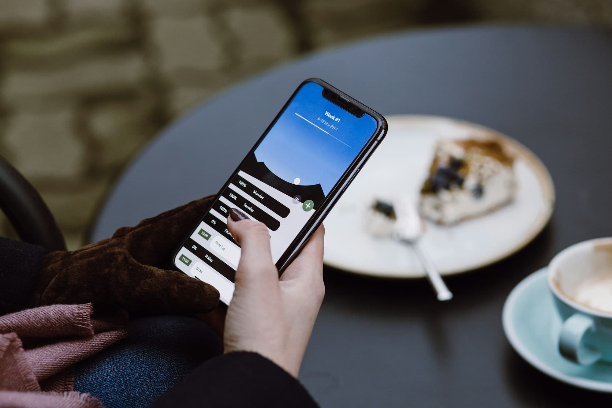 Persona usando su teléfono en una cafetería